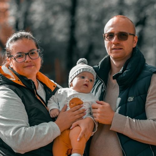 a man and woman holding a baby