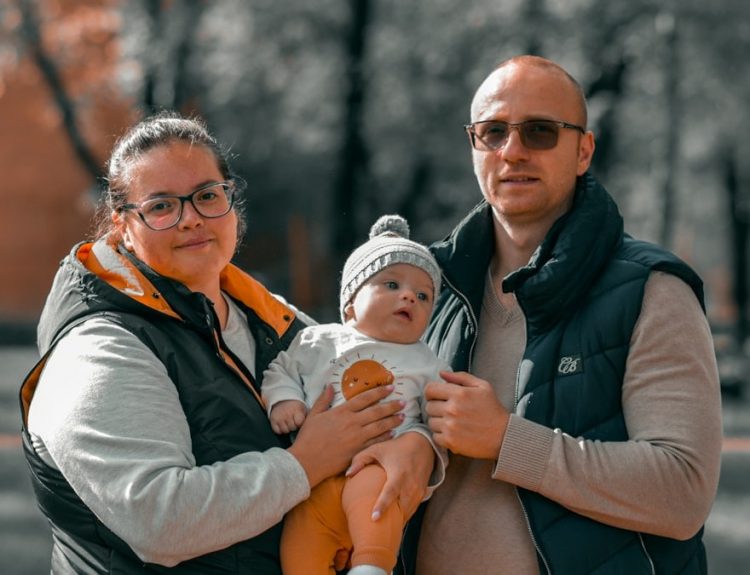 a man and woman holding a baby